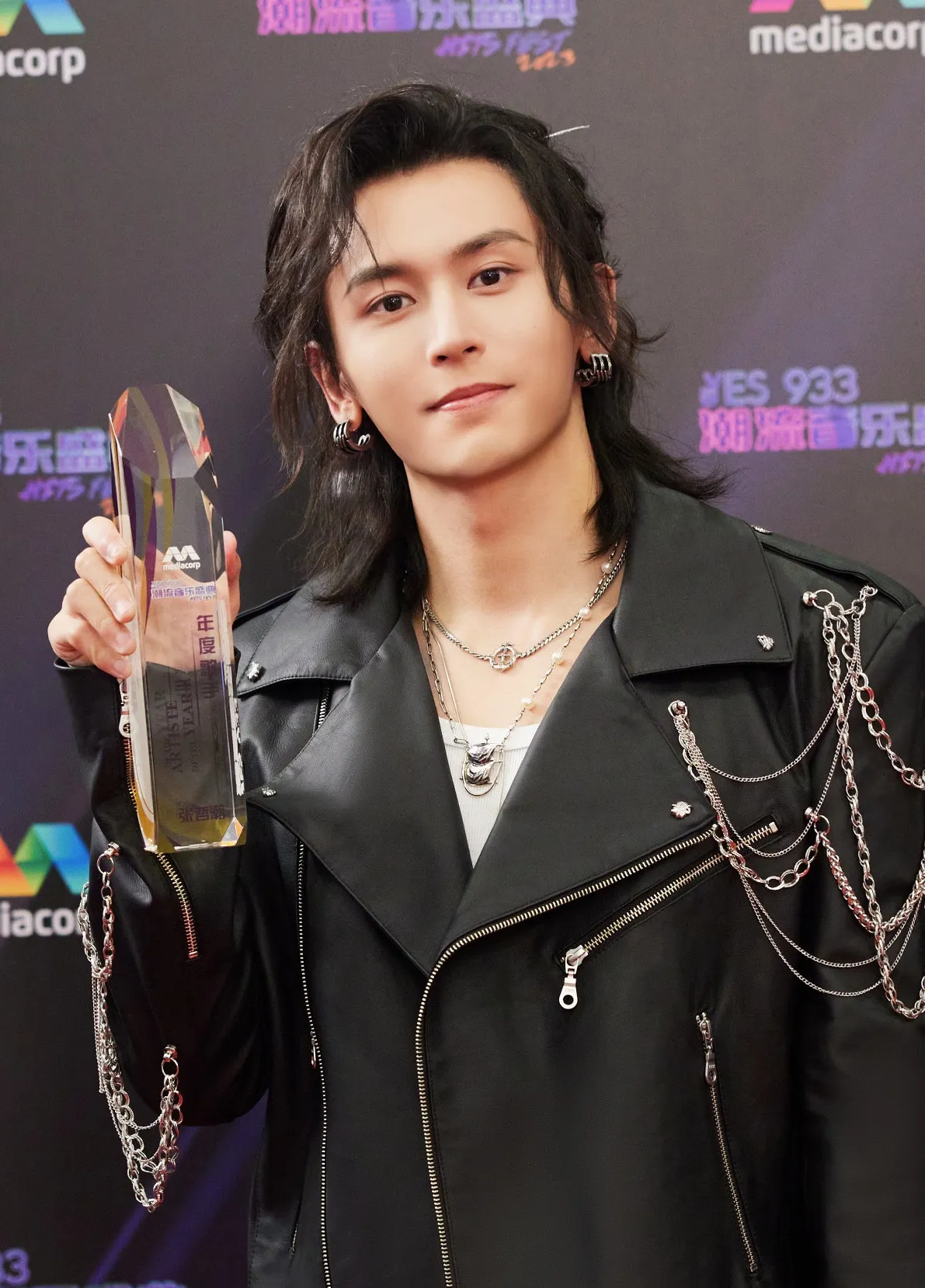 Asian male with layered necklaces, earrings, and styled hair